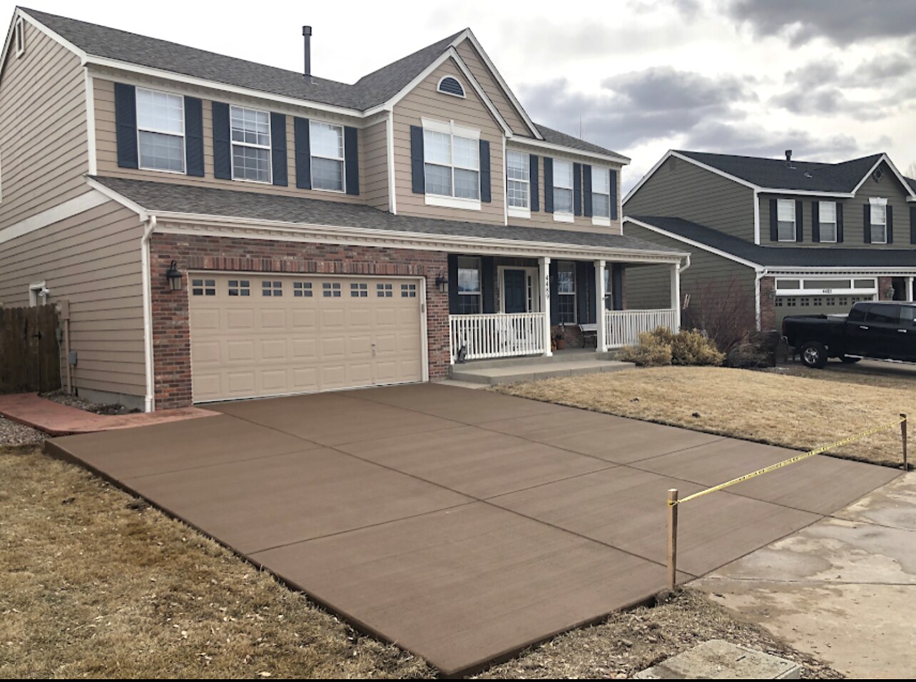 Brown decorative concrete driveway at a two-story home in Colorado Springs.
