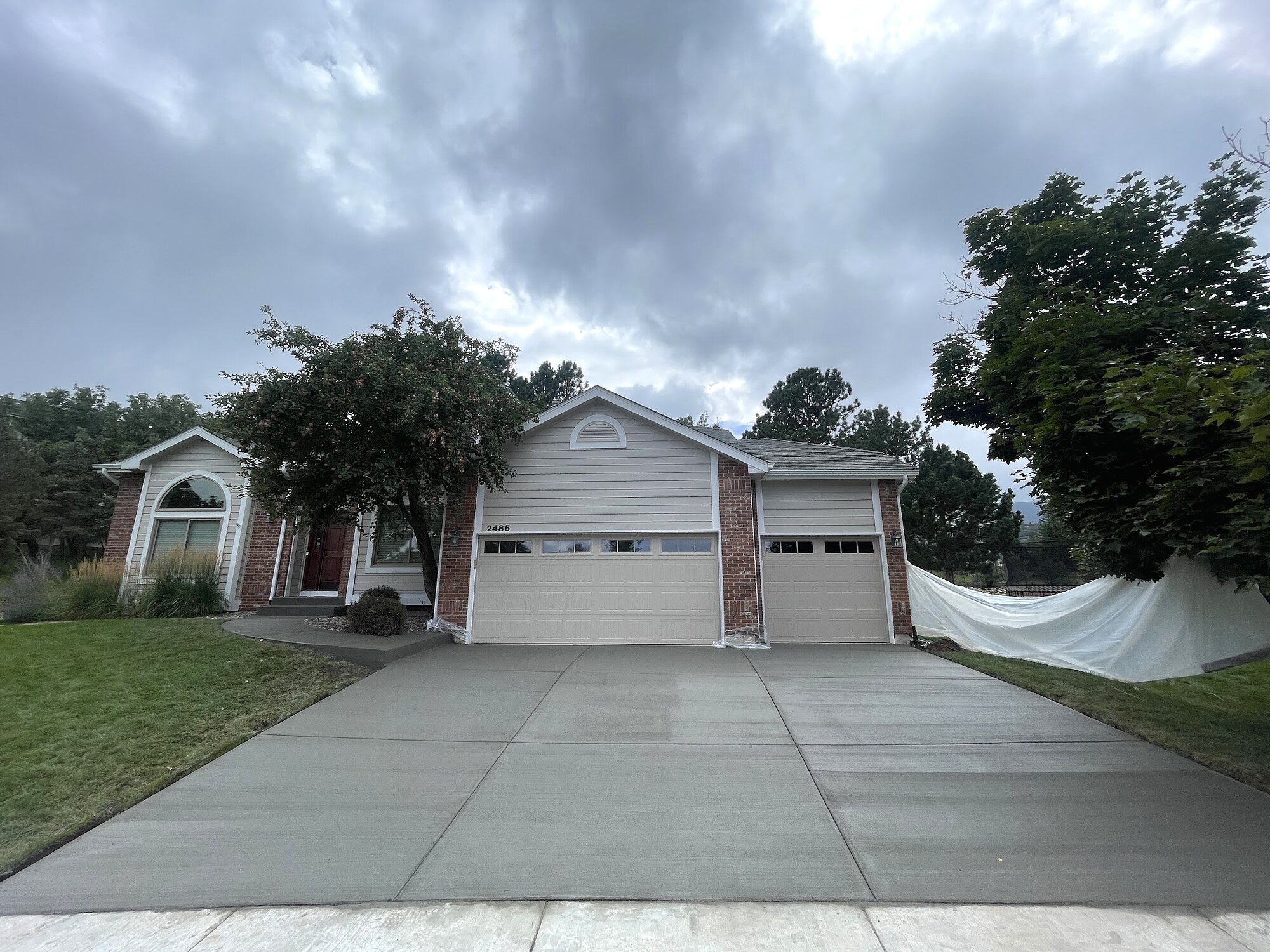 New concrete driveway at a white suburban home in Colorado Springs.