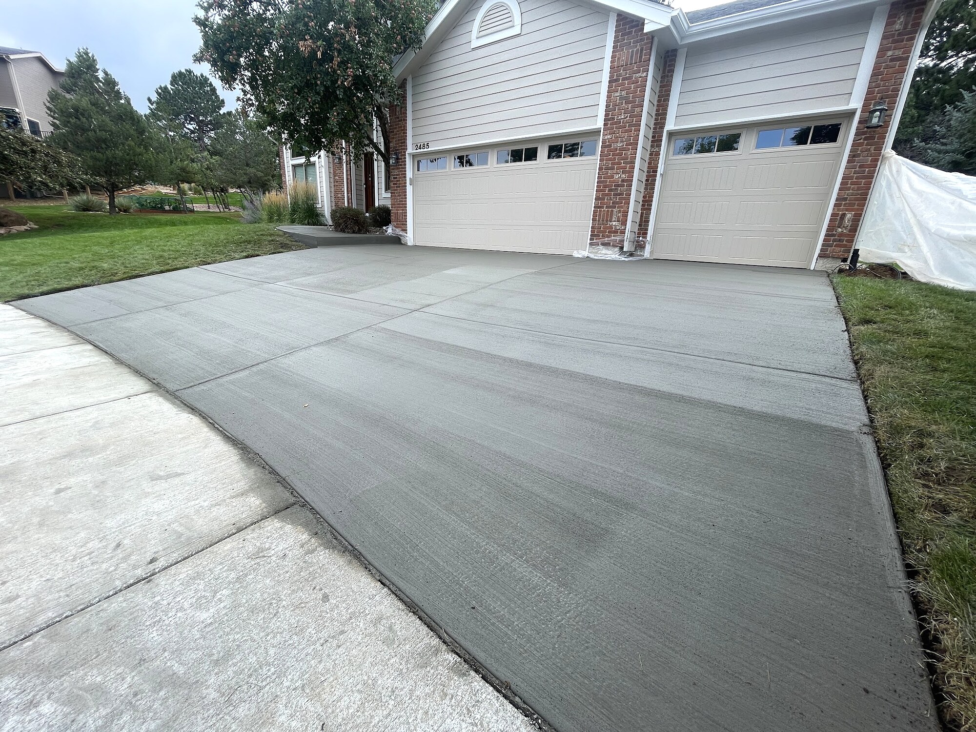 Broom-finished concrete driveway with clean slope transitions in Colorado Springs.