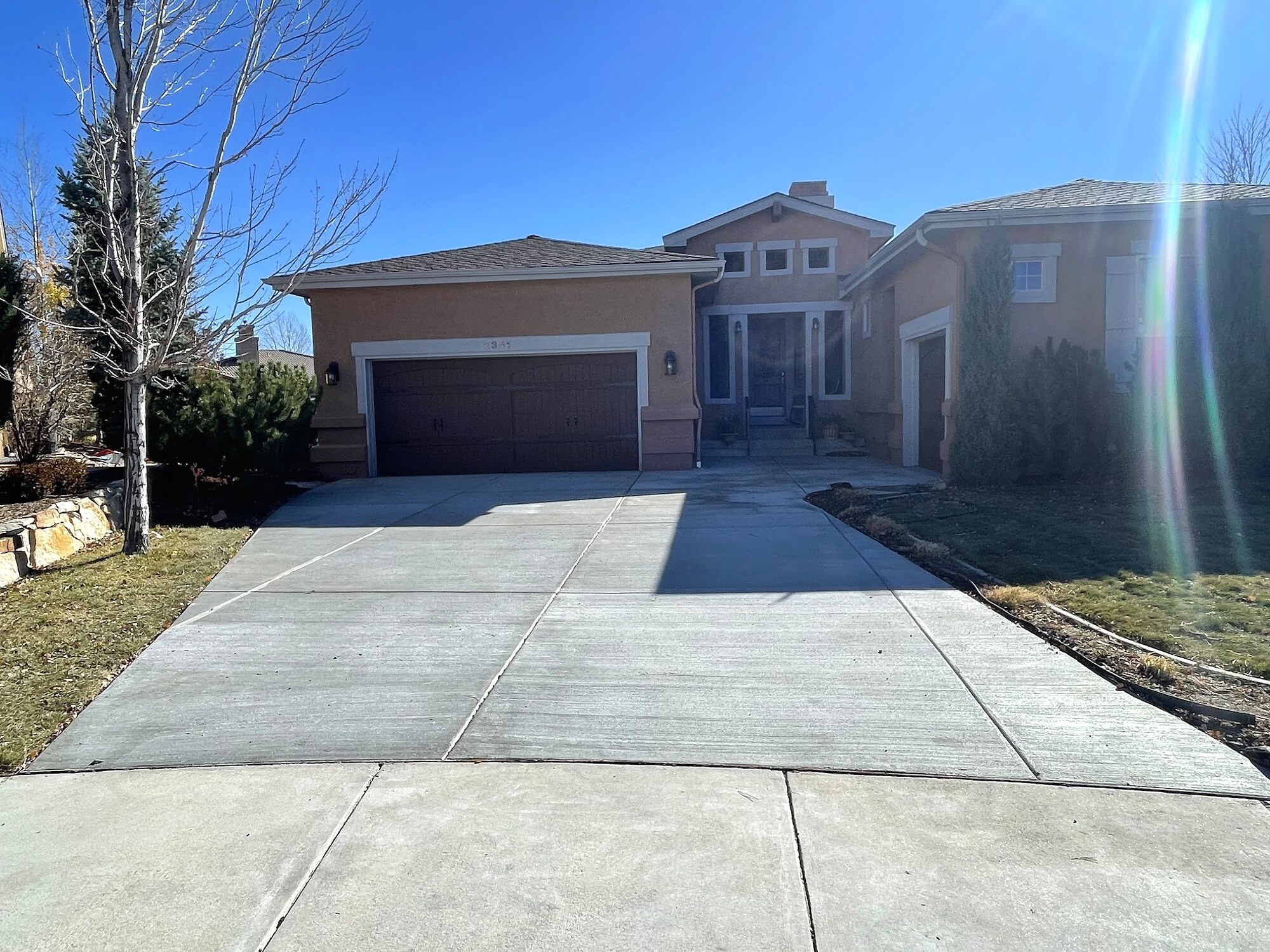 Clean light-gray concrete driveway at a modern home in Colorado Springs.