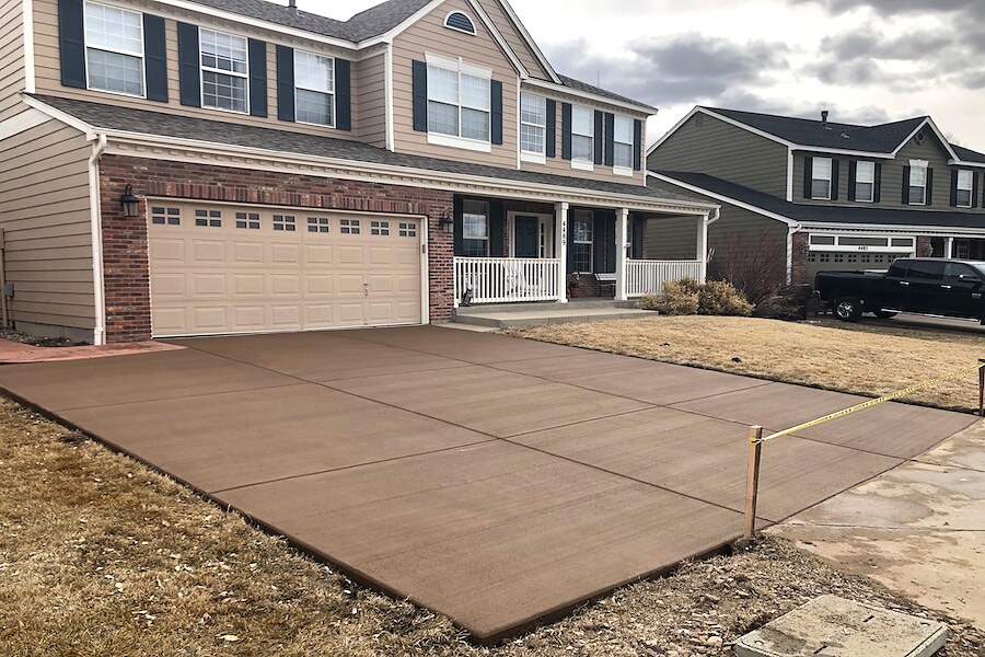 Brown-tinted concrete driveway at a two-story Colorado Springs home.
