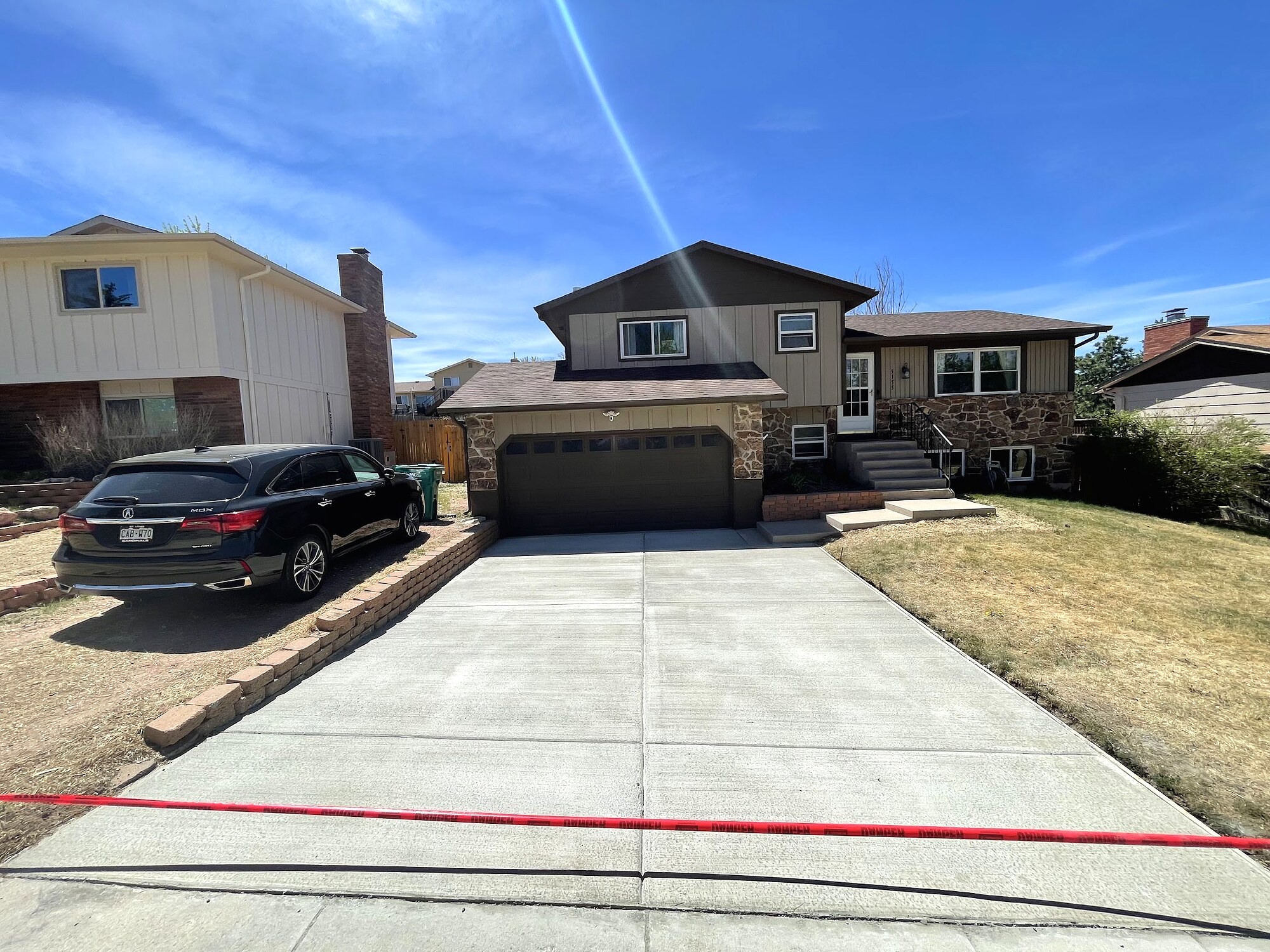 New light-gray concrete driveway at a two-story home in Colorado Springs.