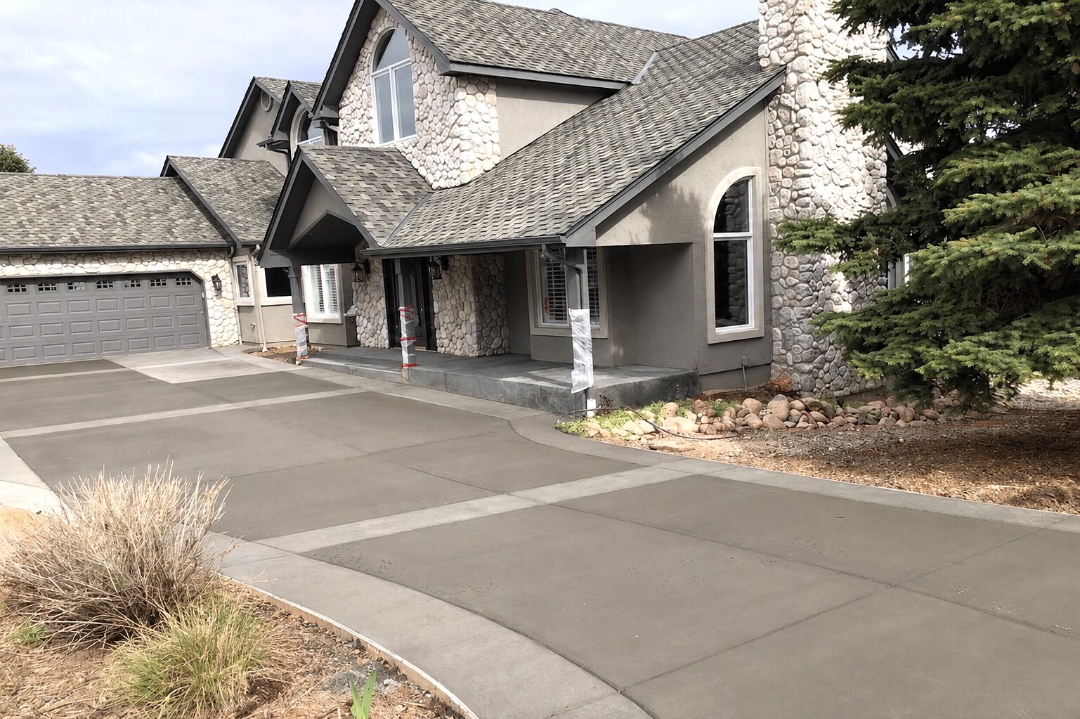 Decorative paneled concrete driveway at a stone-clad home in Colorado Springs.