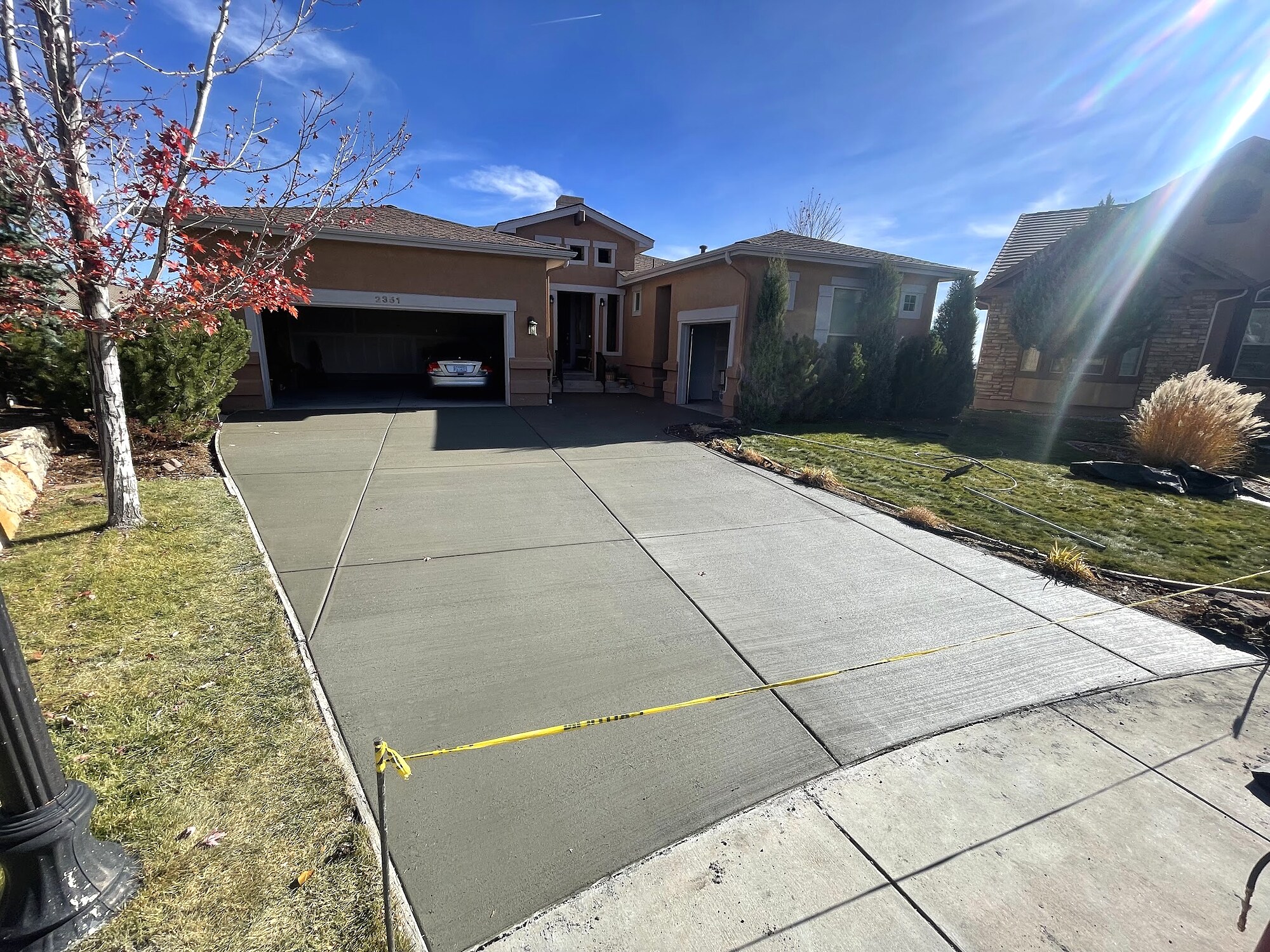 Newly placed concrete driveway at a tan Colorado Springs home.