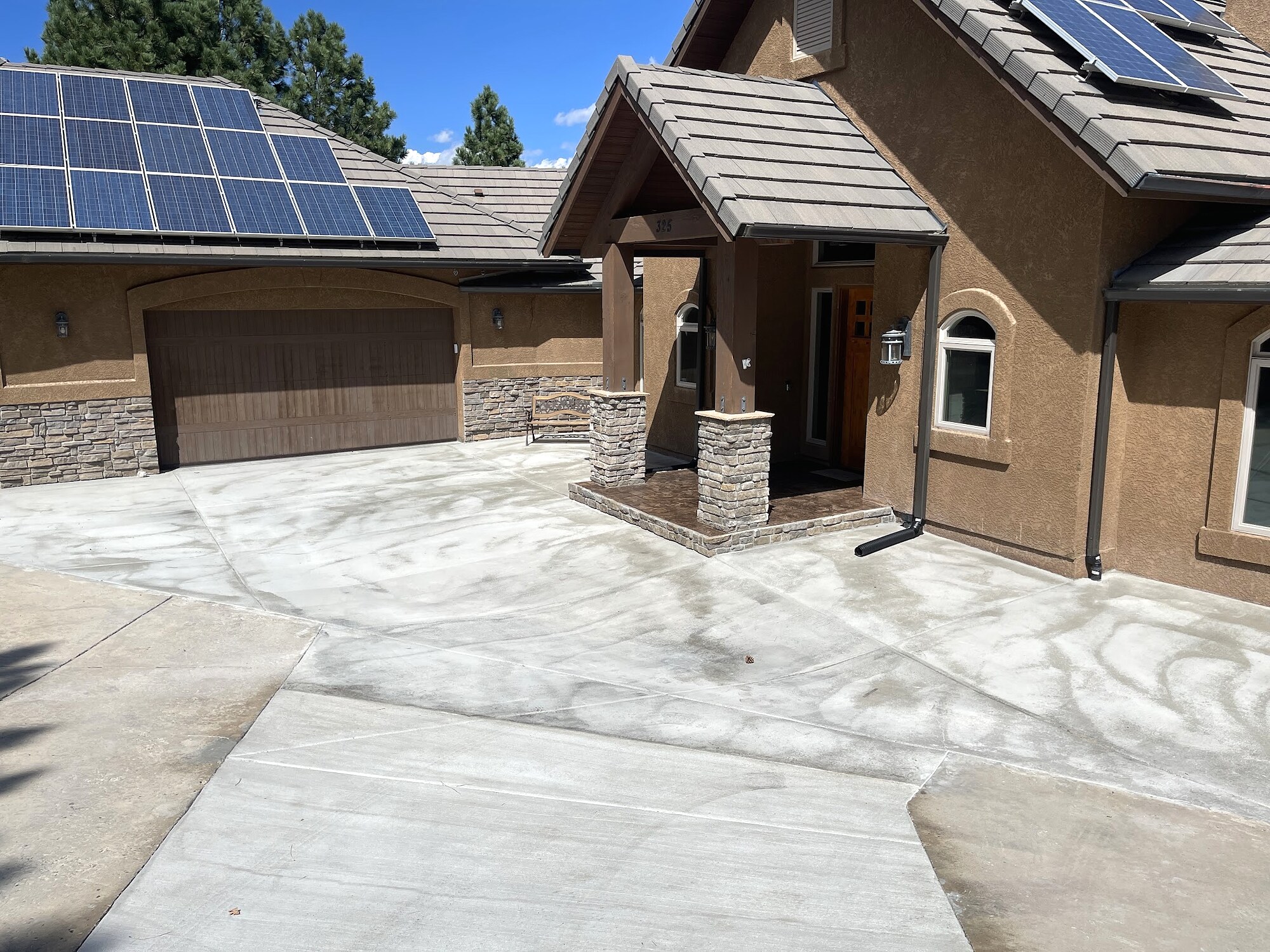 Broad residential concrete driveway at a solar-equipped Colorado Springs home.