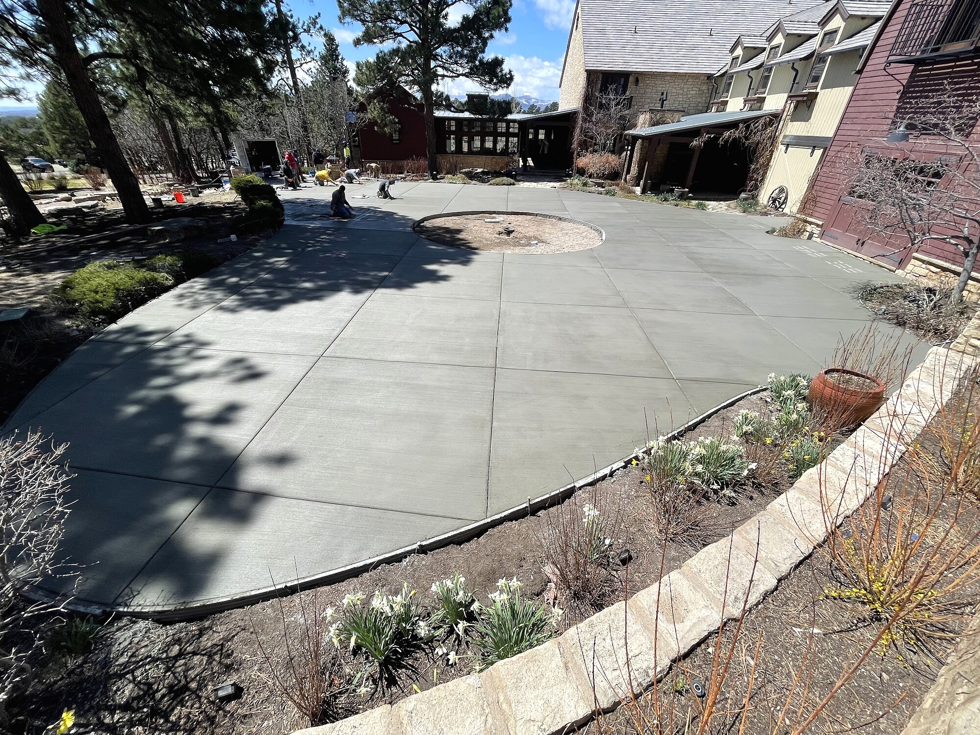 Curved concrete driveway beside a retaining wall and landscaping in Colorado Springs.