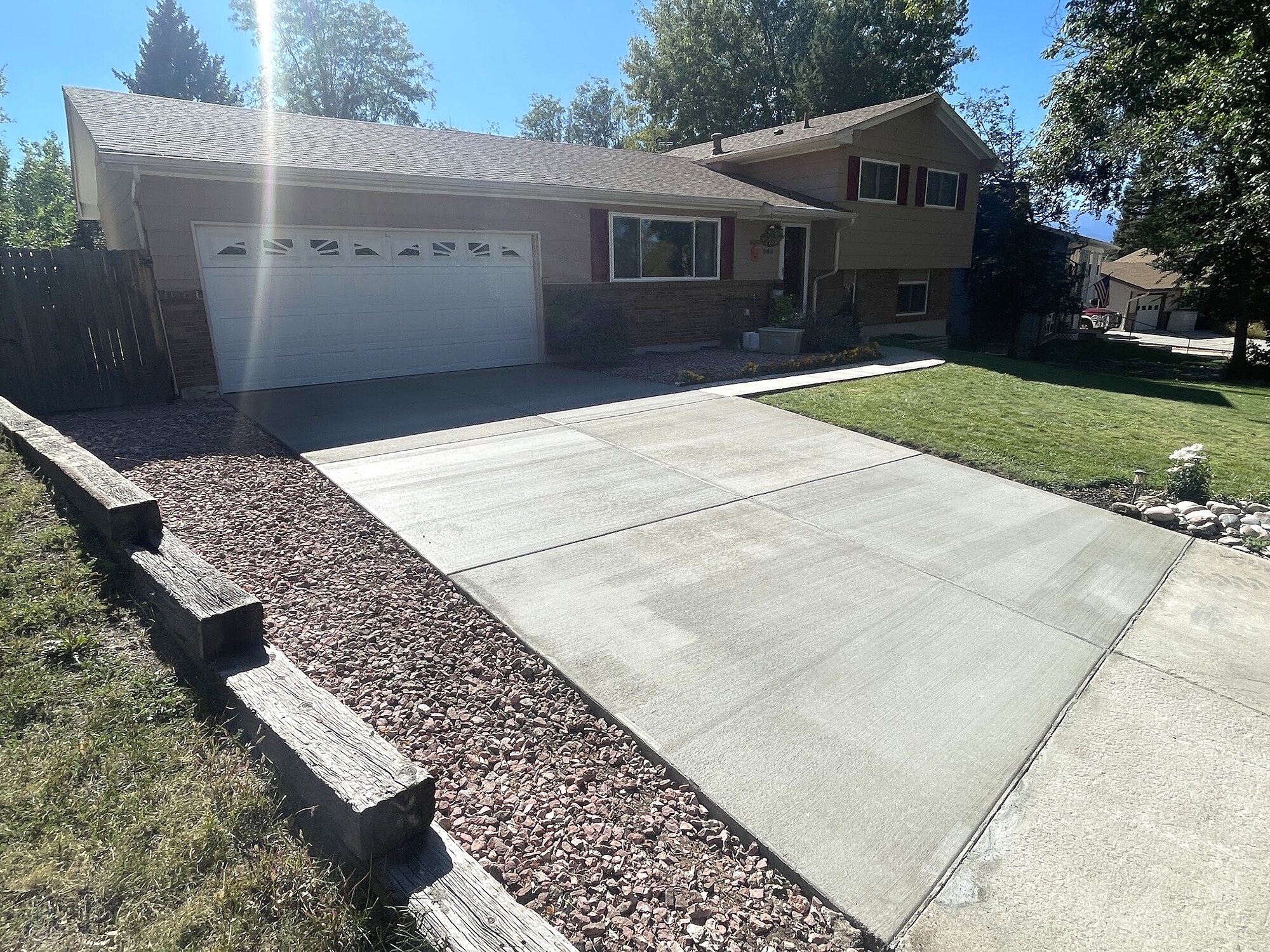 Clean residential concrete driveway with gravel landscaping in Colorado Springs.