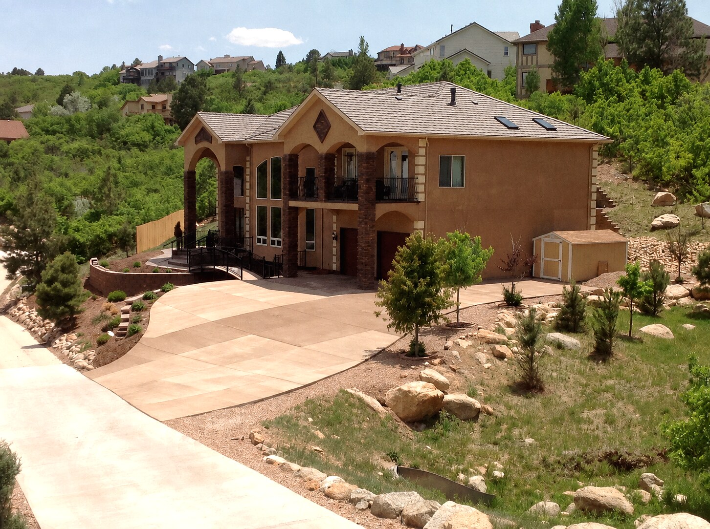 Sweeping multi-tone concrete driveway at a hillside custom home in Colorado Springs.