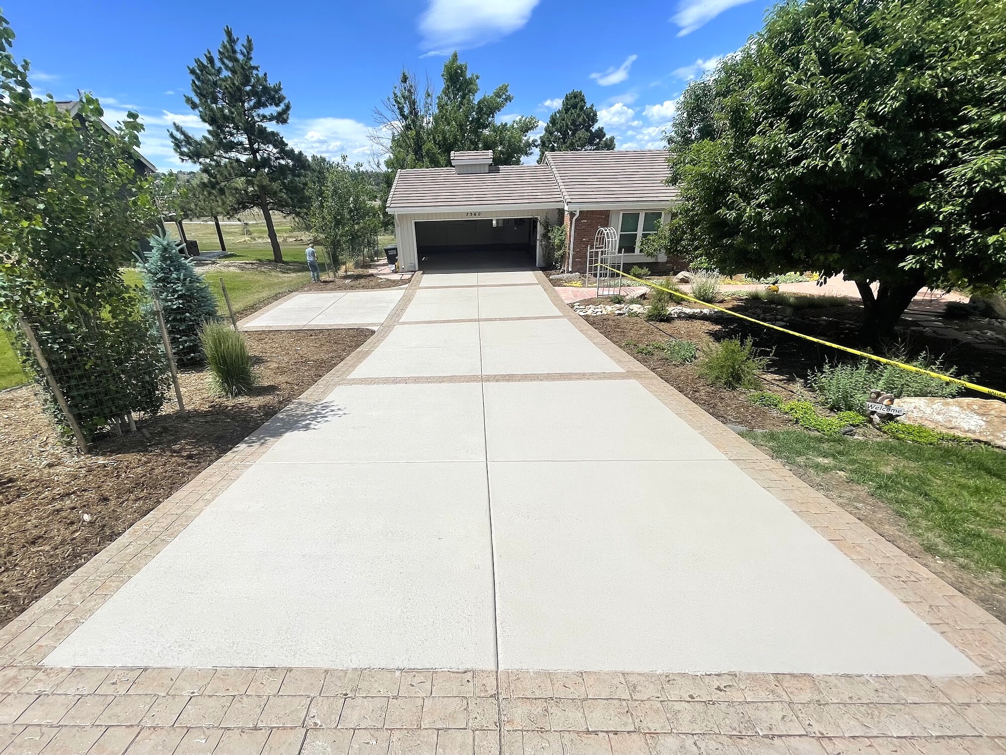 Long concrete driveway with decorative paver borders in Colorado Springs.