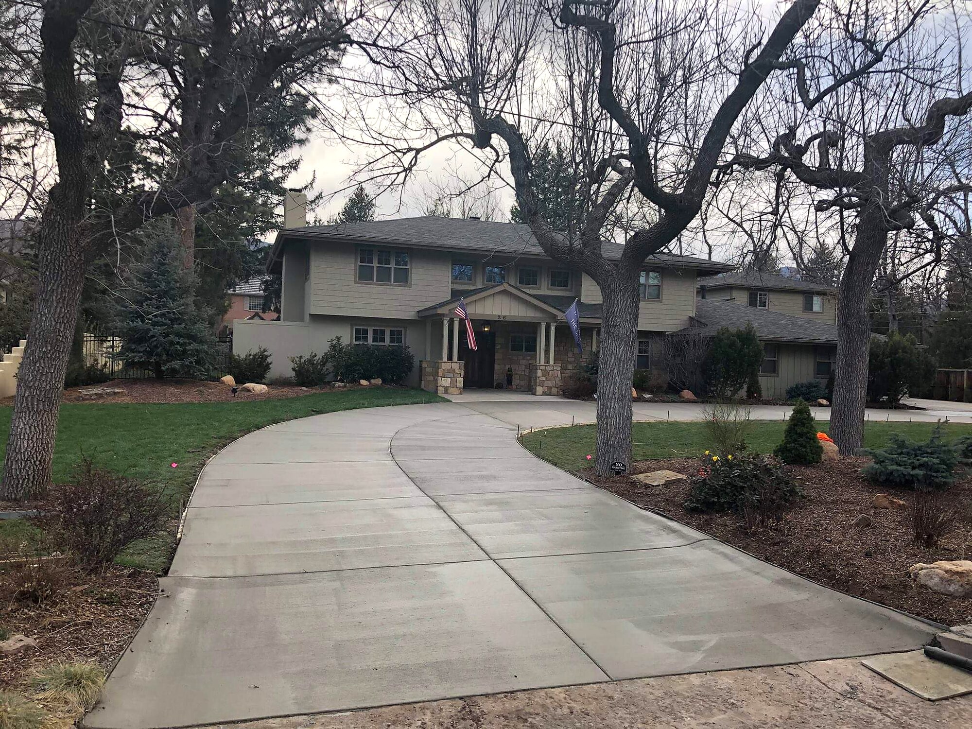 Curved concrete estate driveway through mature trees in Colorado Springs.