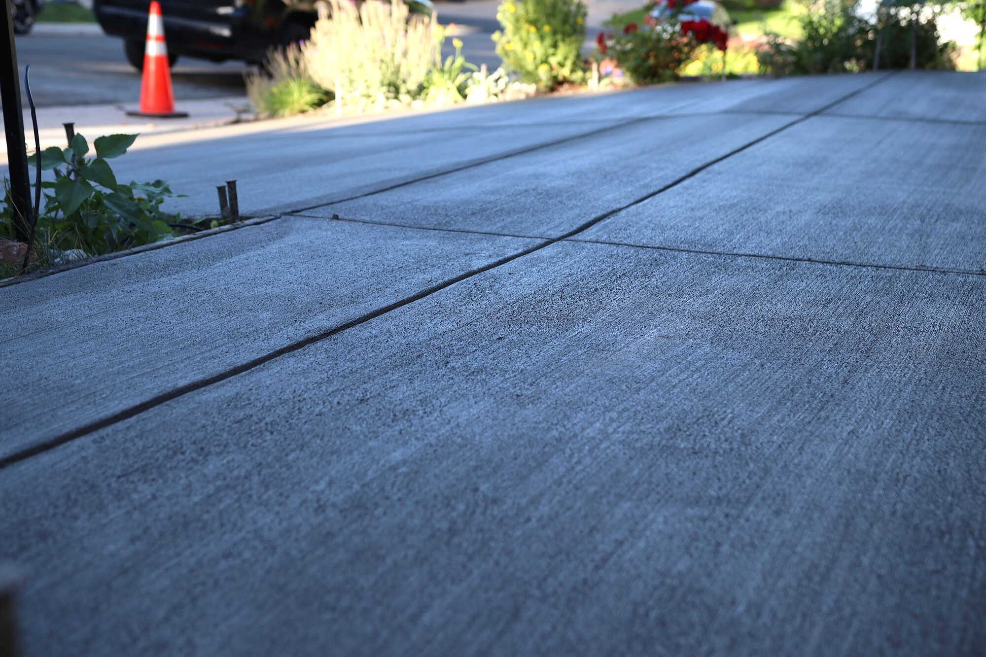 Close view of a broom-finished concrete driveway and control joints in Colorado Springs.